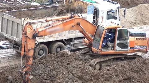 Excavator digs the ground at a construction site Stock Footage