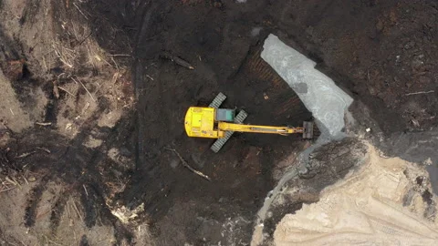 Excavator digs the ground at a construction site. Aerial view. Industrial style. Stock Footage 151083924