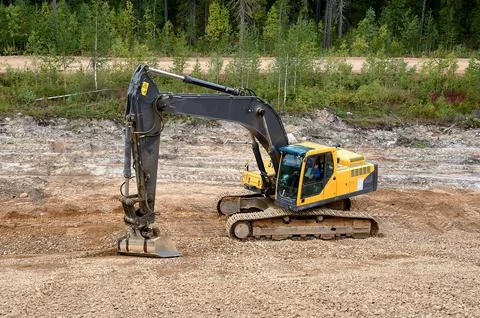Excavator digs the ground Stock Photos