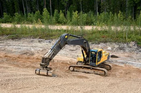 Excavator digs the ground Stock Photos