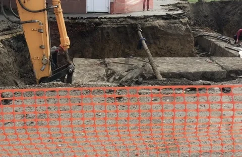 An excavator digs a hole in the city. Stock Footage 136818447