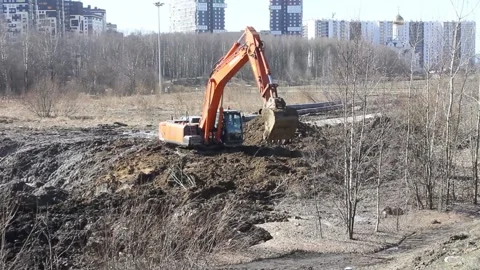 An excavator digs a hole in the spring soft earth Stock Footage 152788036