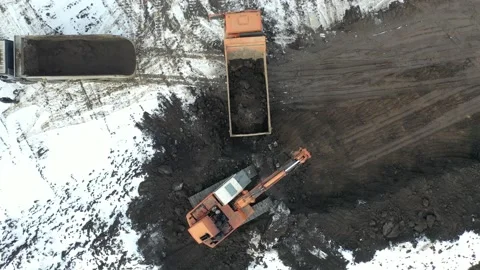 The excavator digs a pit and loads the soil into a dump truck. Drone video. Stock Footage 147094109