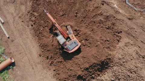 An excavator digs a pit under the foundation of the house, view from above Stock Footage 157694592