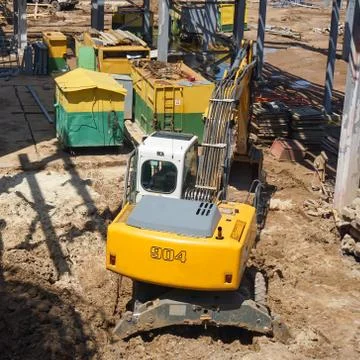 The excavator digs a pit under the foundation of a new overpass for pipelines Stock Photos