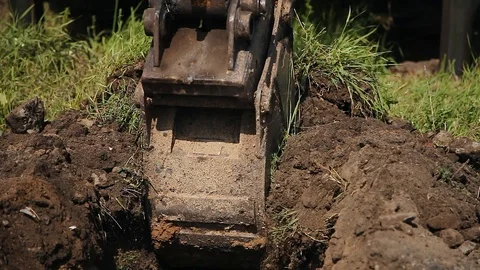 An excavator digs a trench for laying a cable. Excavator digs a trench for Video stock 126323366
