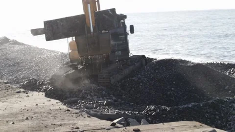 An excavator disassembles the destroyed plates on the seashore, repairing t.. Stock Footage 229243650