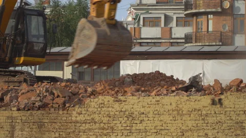 Excavator disassembles the wreckage of an old building, demolished to build a Stock Footage 114139217