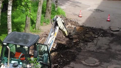 The excavator is doing road work . Working machine. Stock Footage 189995934