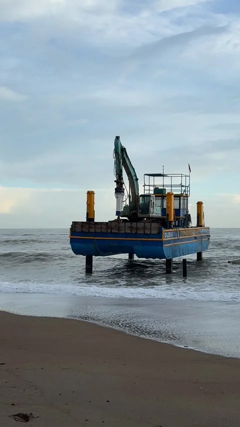 Excavator dredging platform on ocean at beach, showcasing coastal industria.. Stock Footage 330927437