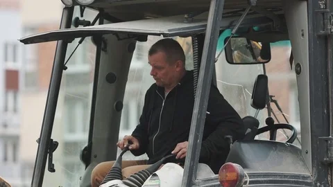 Excavator driver pull triggers in glazed cabin at building site, slowmotion 動画素材 72571362