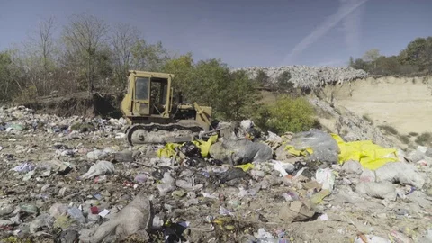 Excavator driver pushing and rolling stacks of junk on dump. Stock Footage 82205907