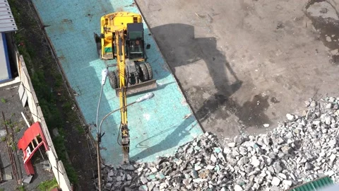 Excavator with a jackhammer breaks many tile panels on the ground. A lot of Stock Footage 136701052