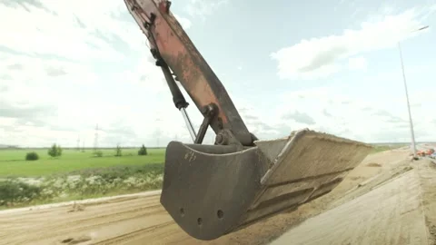 Excavator leveling the roadside with a bucket Stock Footage 285143574