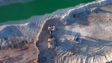 Excavator load limestone in mining truck in open pit mine. Video stock 186510137