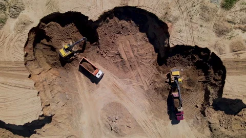 Excavator load the sand into dump truck. Backhoe on earthworks. Видео 156628060