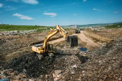 Excavator loader, bulldozer working in garbage dump. Recycling  Stock Photos