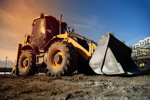 Excavator loader machine at demolition construction site , sunset time . Stock Photos