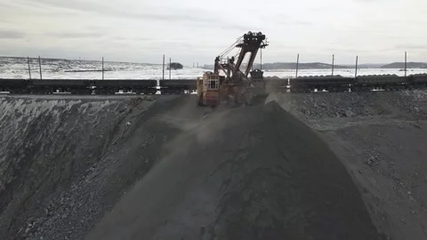 Excavator loading coal onto train at mine, aerial views of train and mine Stock Footage 326179467