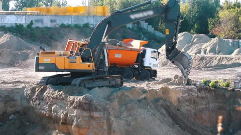 The excavator loading crushed stone into a dump truck in a crushed stone quarry Stock Footage 211437495