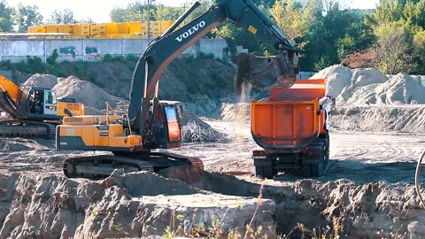 The excavator loading crushed stone into a dump truck in a crushed stone quarry Stock Footage 228718924
