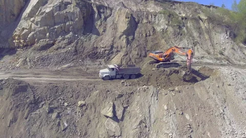 Excavator loading a dump truck with rock in a quarry Stock Footage 131380097