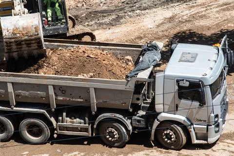 Excavator loading a dump truck with soil Photos