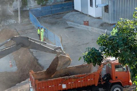 Excavator loading a dump truck with soil Photos