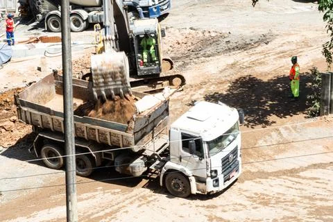 Excavator loading a dump truck with soil Photos