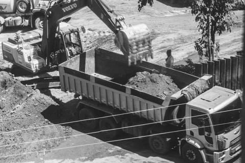 Excavator loading a dump truck with soil Photos