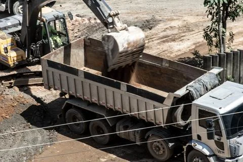 Excavator loading a dump truck with soil Photos