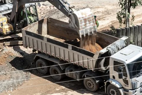 Excavator loading a dump truck with soil Photos