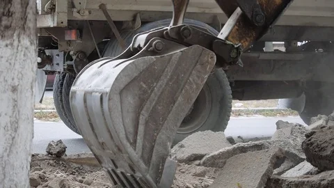 Excavator loading fragmented asphalt on a dump truck Stock Footage 69857395