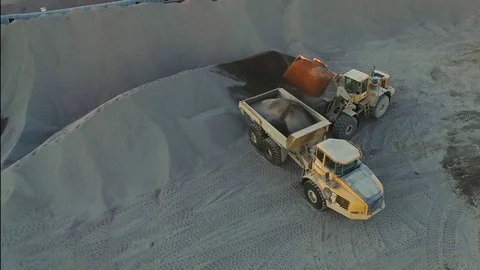 Excavator loading granite or ore into dump truck at opencast, top viewe Stock Footage 74373449