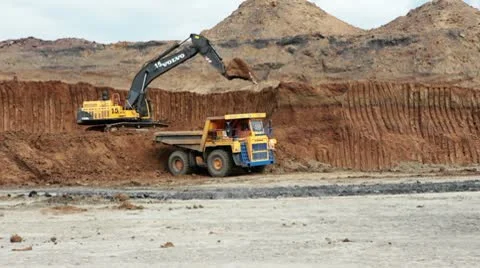 Excavator loading huge dump trucks Stock Footage 10756572