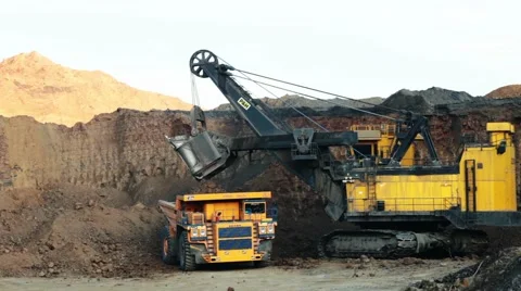 Excavator loading huge dump into trucks Stock Footage 49387816