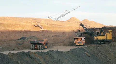 Excavator loading huge dump into trucks Stock Footage 49387899