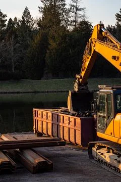 Excavator Loading Metal Scrap in Container Stock Photos