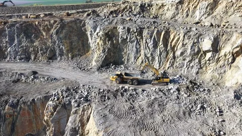 Excavator Loading Reversing Dump Truck in Granite Quarry Stock-Footage 348232745
