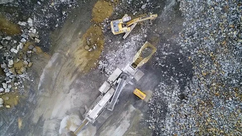 Excavator loading rock into crusher 2 Stock Footage 115735553