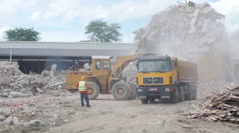 Excavator loading rubble in truck, big pile of broken bricks in background. Stock Footage 64036756