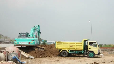 An excavator is loading some soil into a dump truck. Stock Footage 159603653