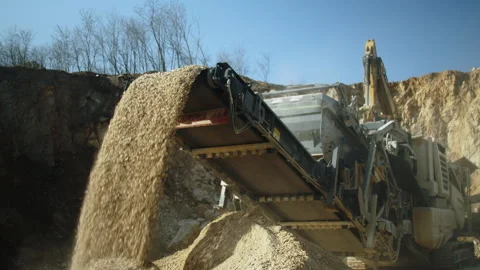Excavator loading stone in crushing machine, rocks falling, quarry open pit Video stock 293962881