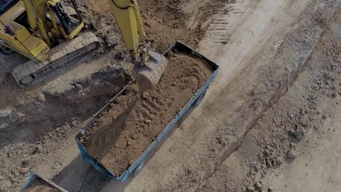 Excavator loading a truck on a construction site Stock Footage