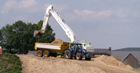 Excavator loading yellow earth into tractor and trailer Stock Footage 109550799