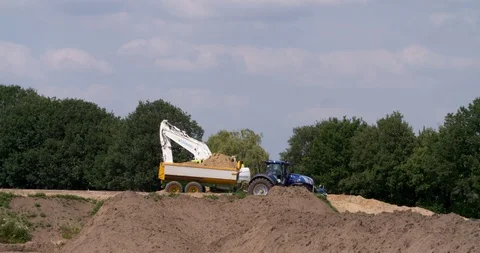 Excavator loading yellow earth into tractor and trailer Stock Footage 109550964