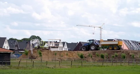 Excavator loading yellow earth into tractor and trailer at construction site Stock Footage 109836701