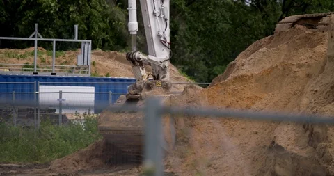 Excavator loading yellow earth into trailer at construction site Stock Footage 109844493