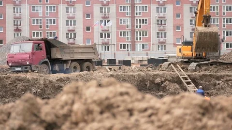 Excavator loads clay using bucket into dump truck Stock Footage 78042142