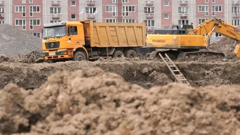 Excavator loads clay using bucket into dump truck Stock Footage 79624725